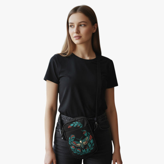 Modelo con bolso urbano negro cruzado con estampado de polilla azul y hojas en tonos verdes.