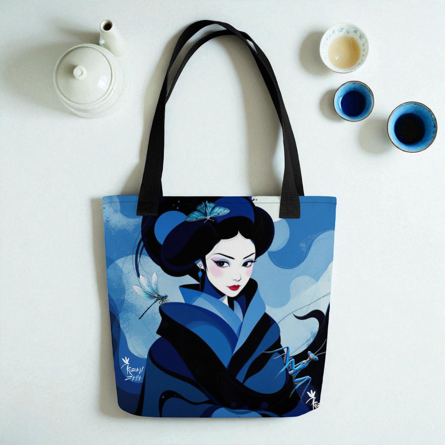 Bolso tote Geisha Azul sobre superficie blanca con tetera kyusu y tazas yunomi vistas desde arriba.
