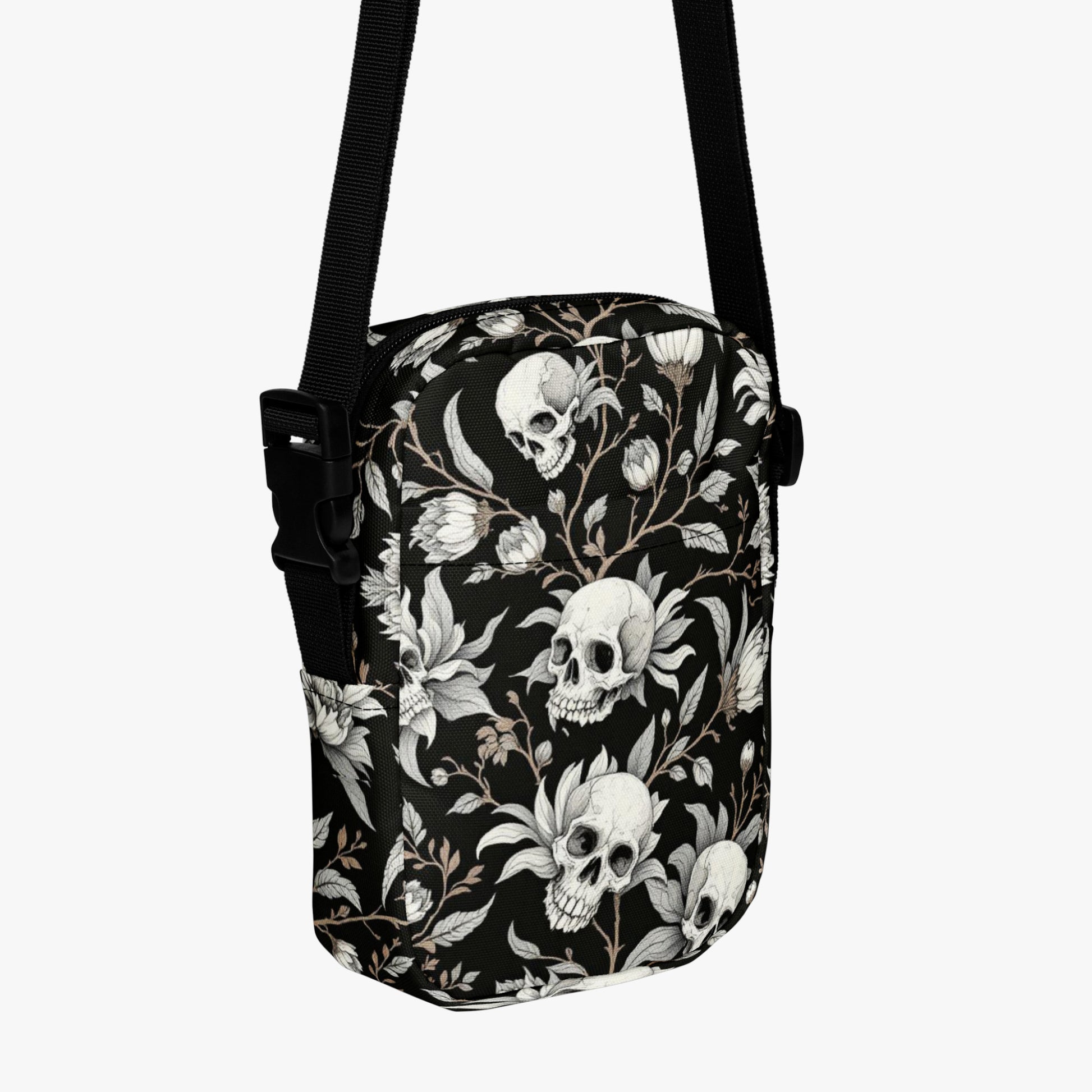 Bolso bandolera negro con calaveras y flores vista tres cuartos