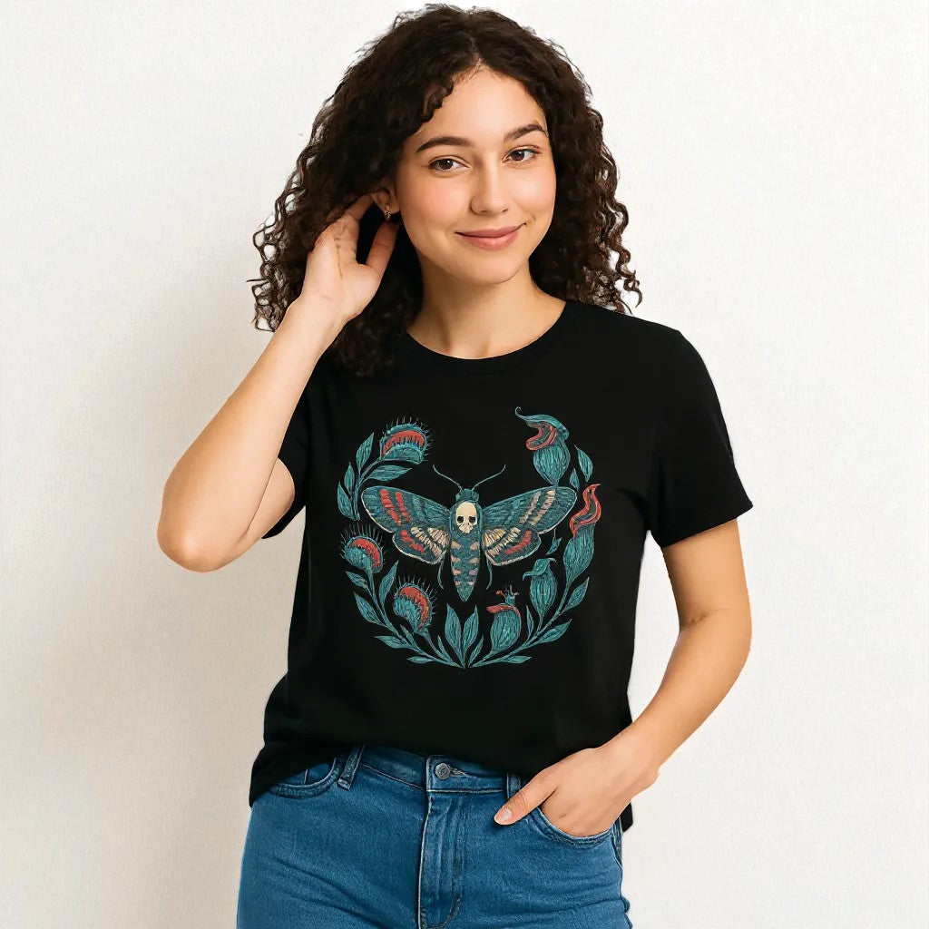Camiseta eco unisex negra con ilustración de polilla calavera en corona botánica, vista frontal en modelo mujer.