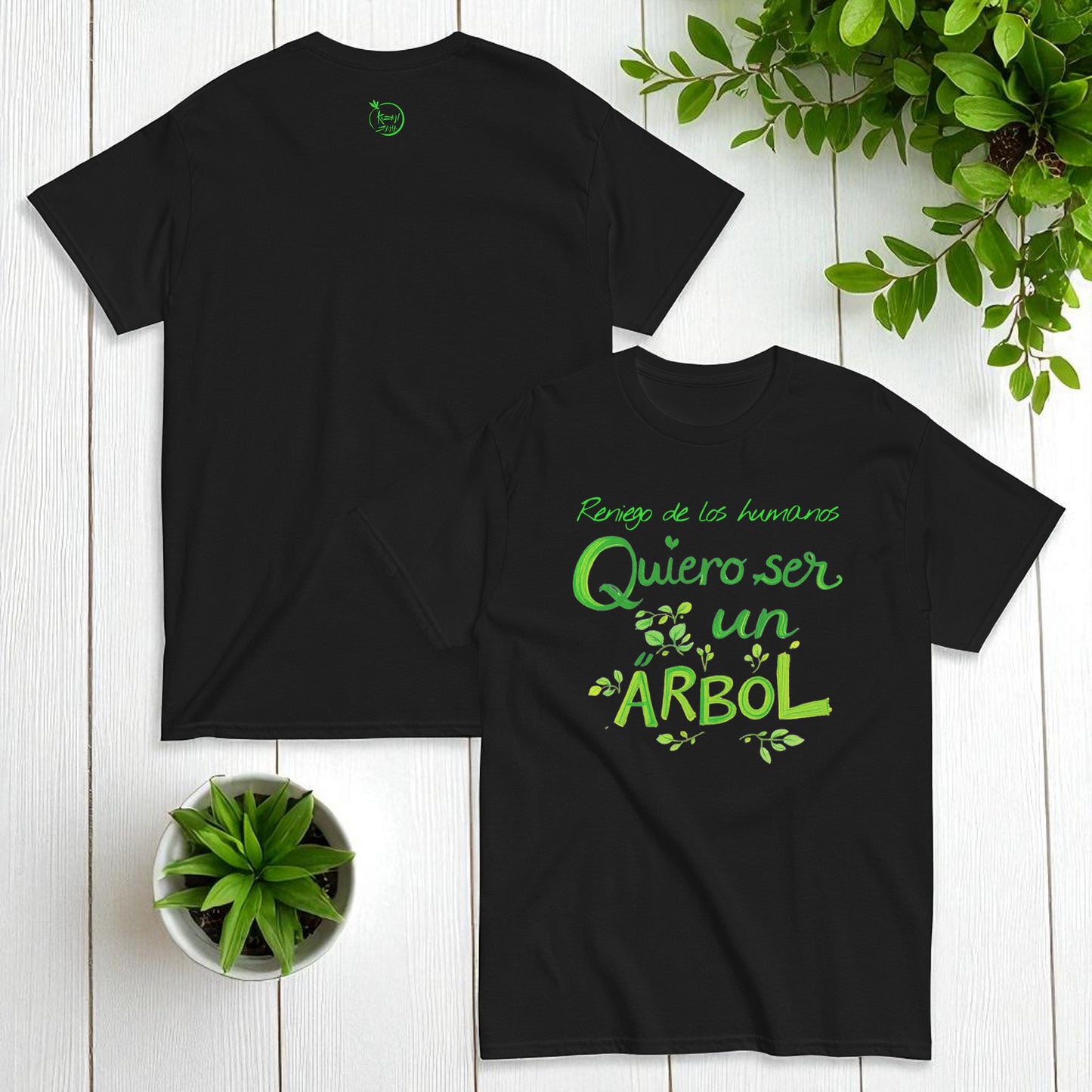 Camiseta negra unisex con frase Reniego de los humanos quiero ser un árbol en plano cenital con accesorios y planta