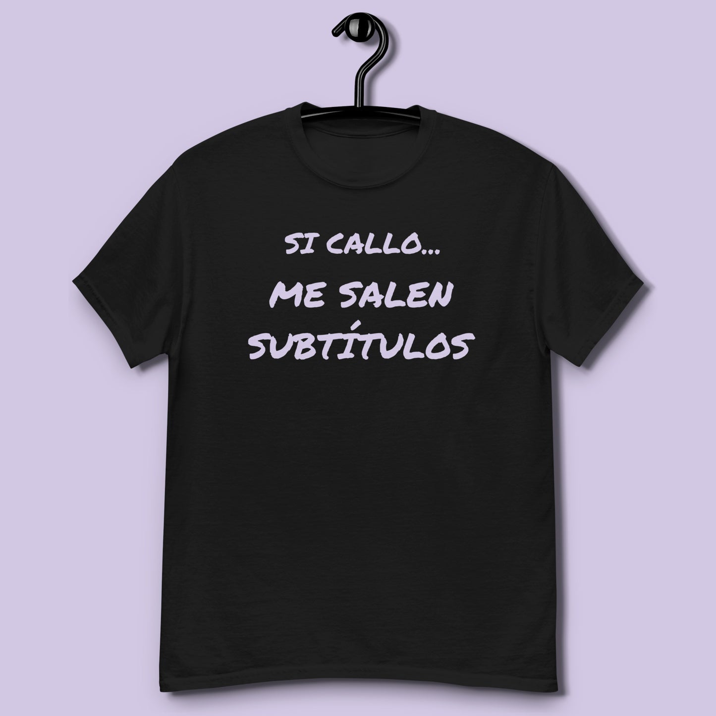 Camiseta negra unisex con frase Si callo me salen subtítulos colgada en percha vista frontal