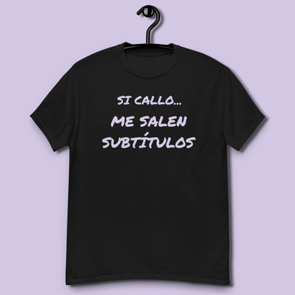 Camiseta negra unisex con frase Si callo me salen subtítulos colgada en percha vista frontal