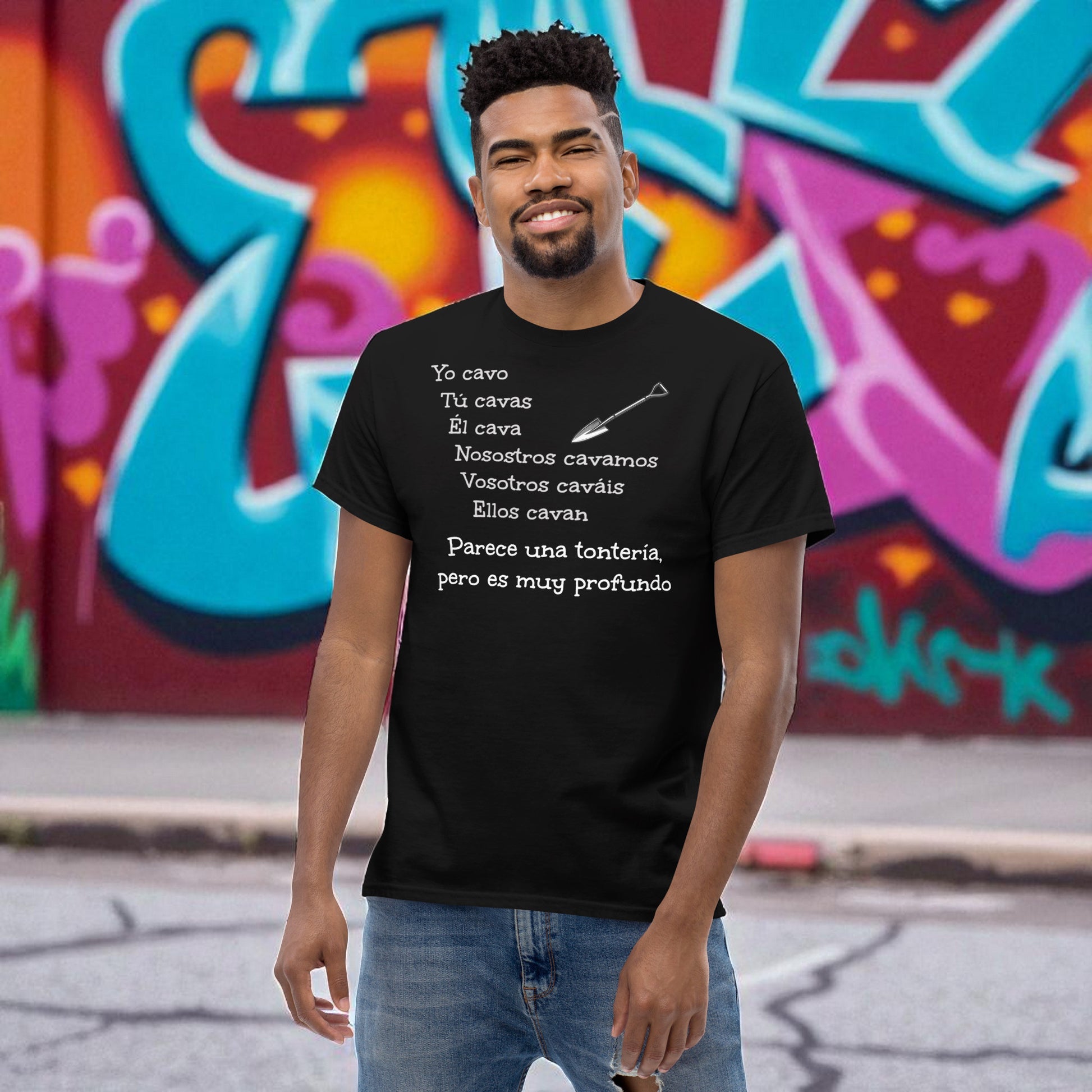 Hombre frente a mural con camiseta negra con frase de broma yo cavo