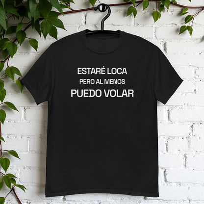 Camiseta negra en percha sobre pared blanca con la frase estare loca pero al menos puedo volar