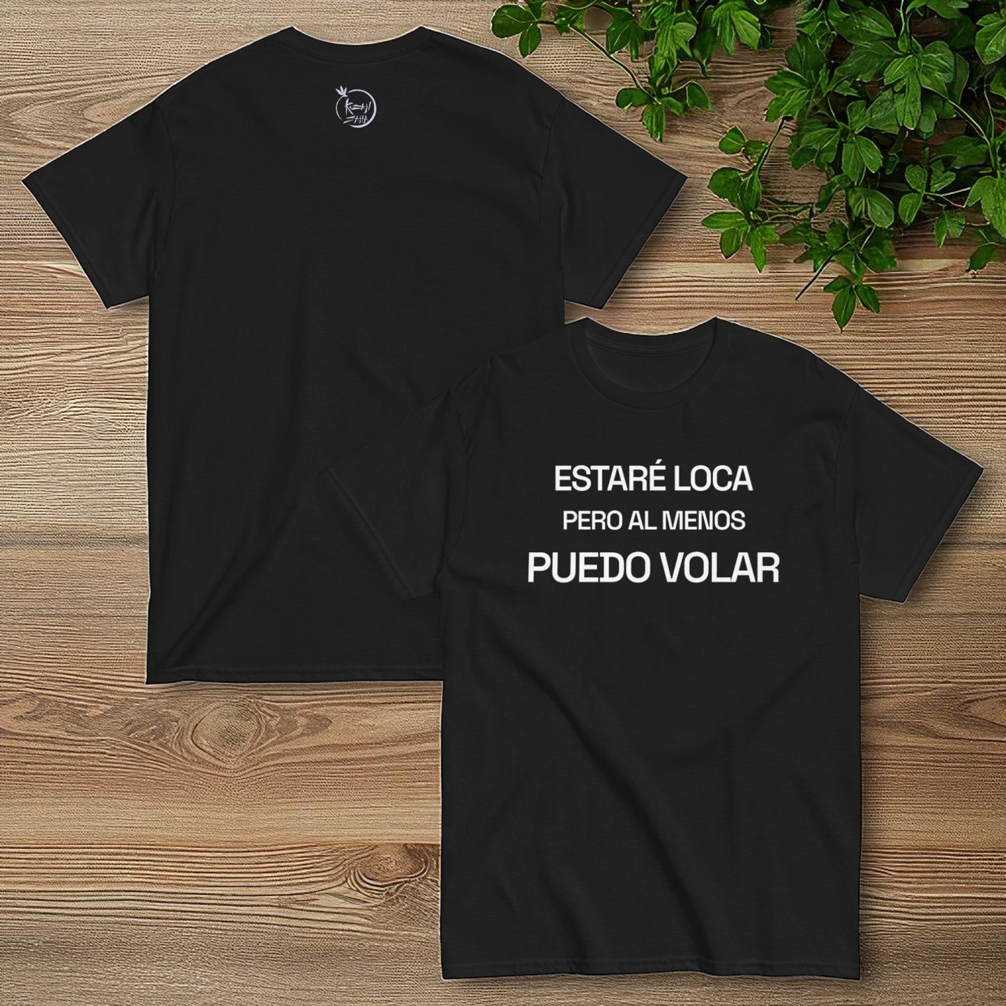 Camiseta negra frente y espalda con la frase estare loca pero al menos puedo volar sobre fondo de madera