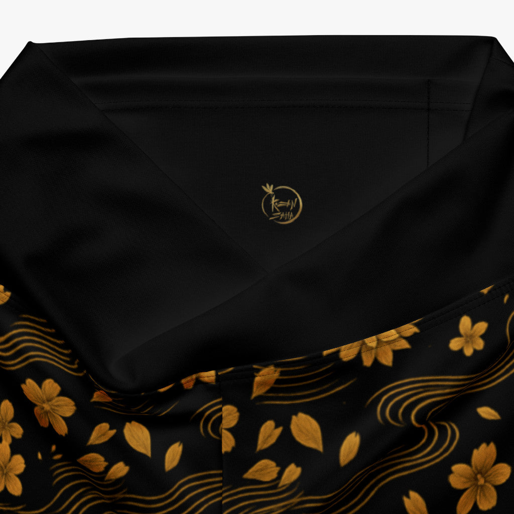 Detalle de cintura con logo Kuzen Saha y flores doradas.