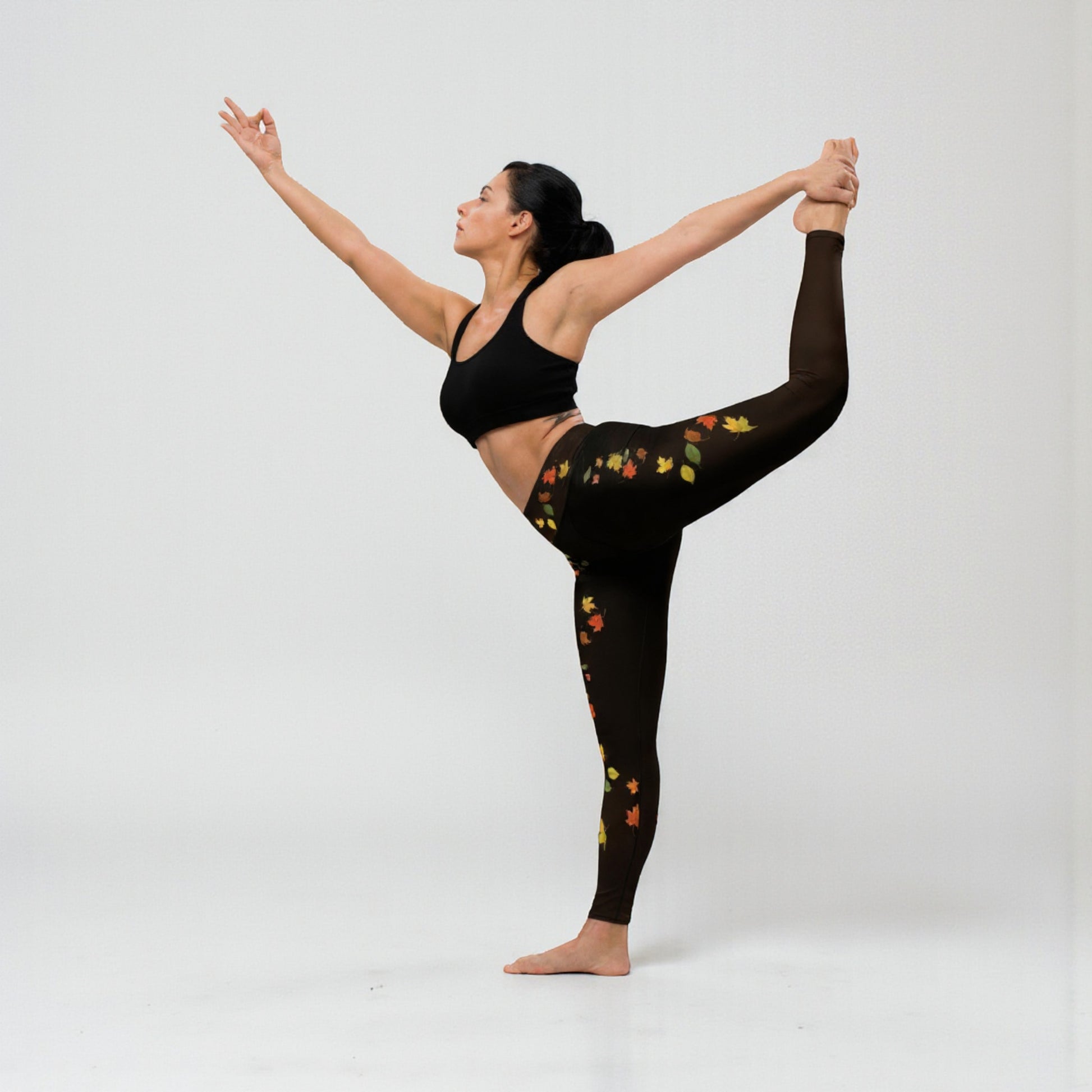 Modelo en postura de equilibrio con leggings de hojas