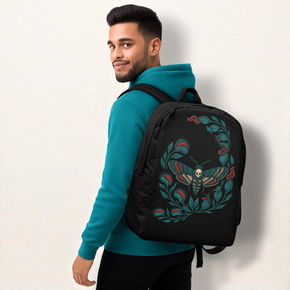 Hombre con sudadera azul petróleo en tres cuartos, llevando mochila negra con diseño de polilla