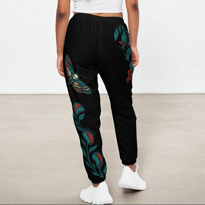 Vista posterior del pantalón en modelo mujer, motivo botánico visible.