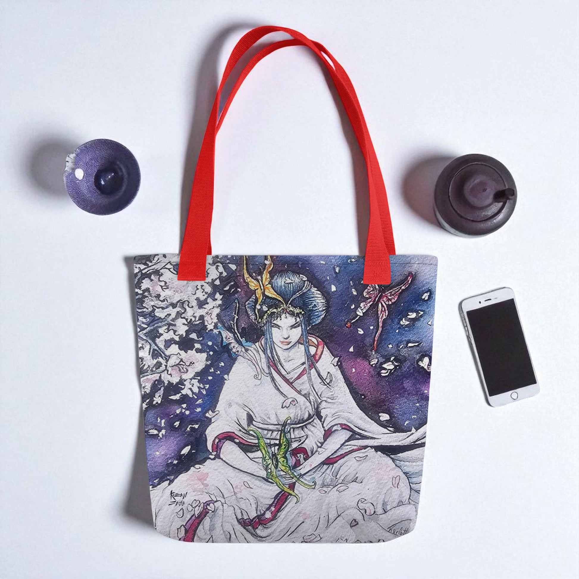 Bolso tote Paz Interior en vista superior sobre superficie blanca con pequeños elementos de cerámica, asas rojas.