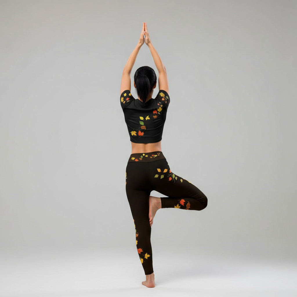 Postura de árbol yoga espalda  mostrando leggings negros con hojas otoñales