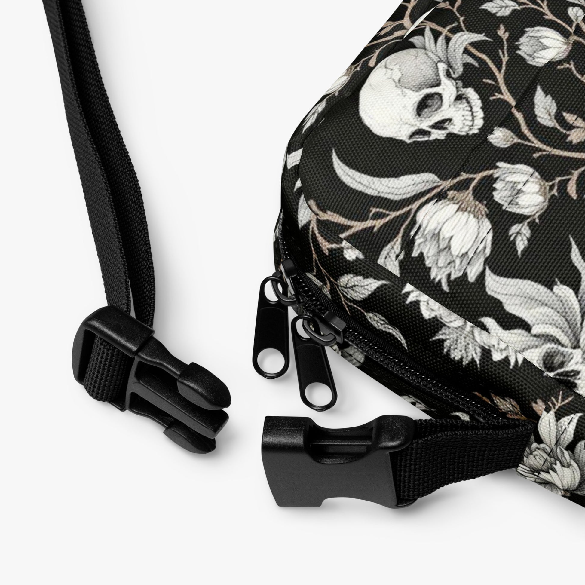 Bolso bandolera negro con calaveras y flores detalle de correa ajustable