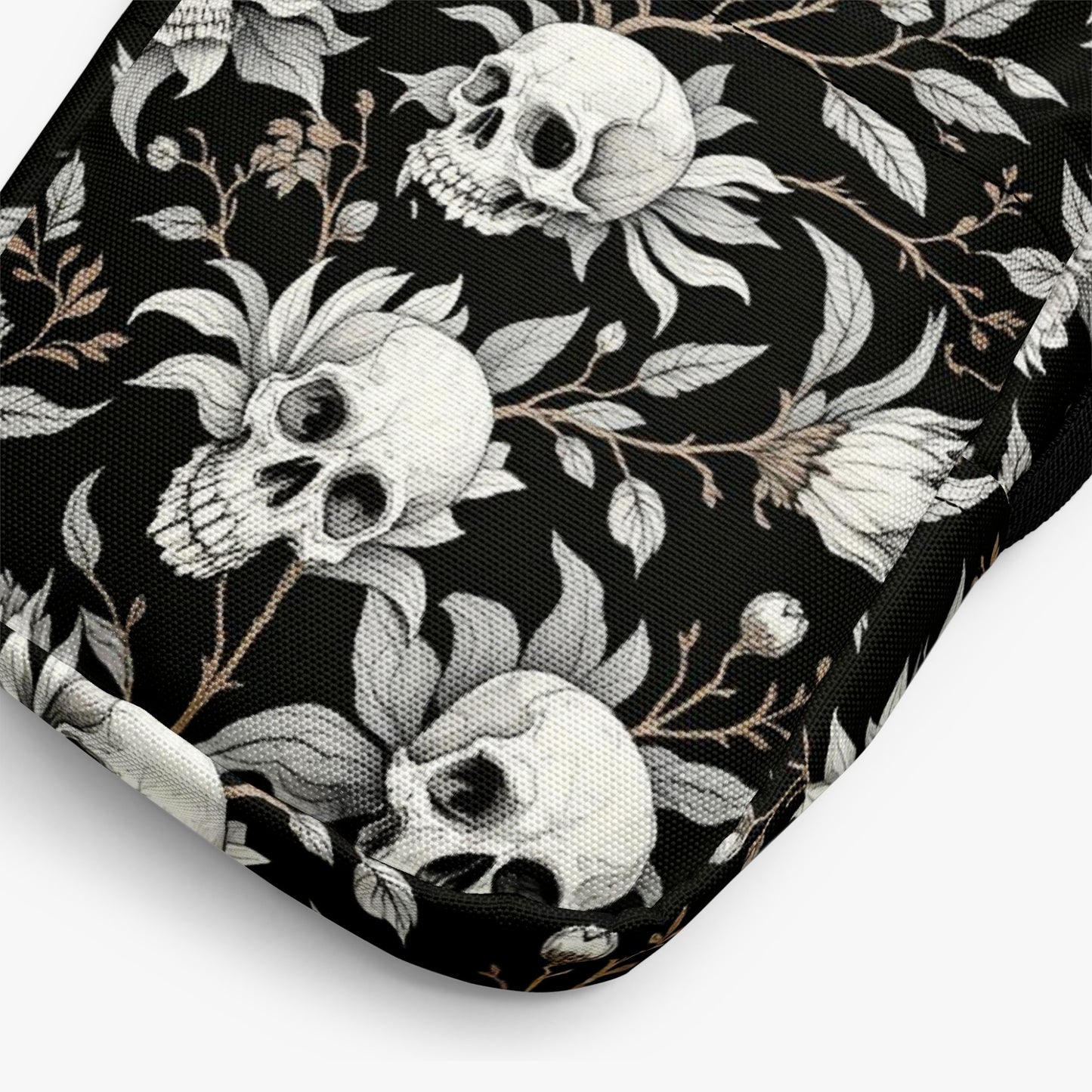 Bolso bandolera negro con calaveras y flores detalle del estampado en primer plano