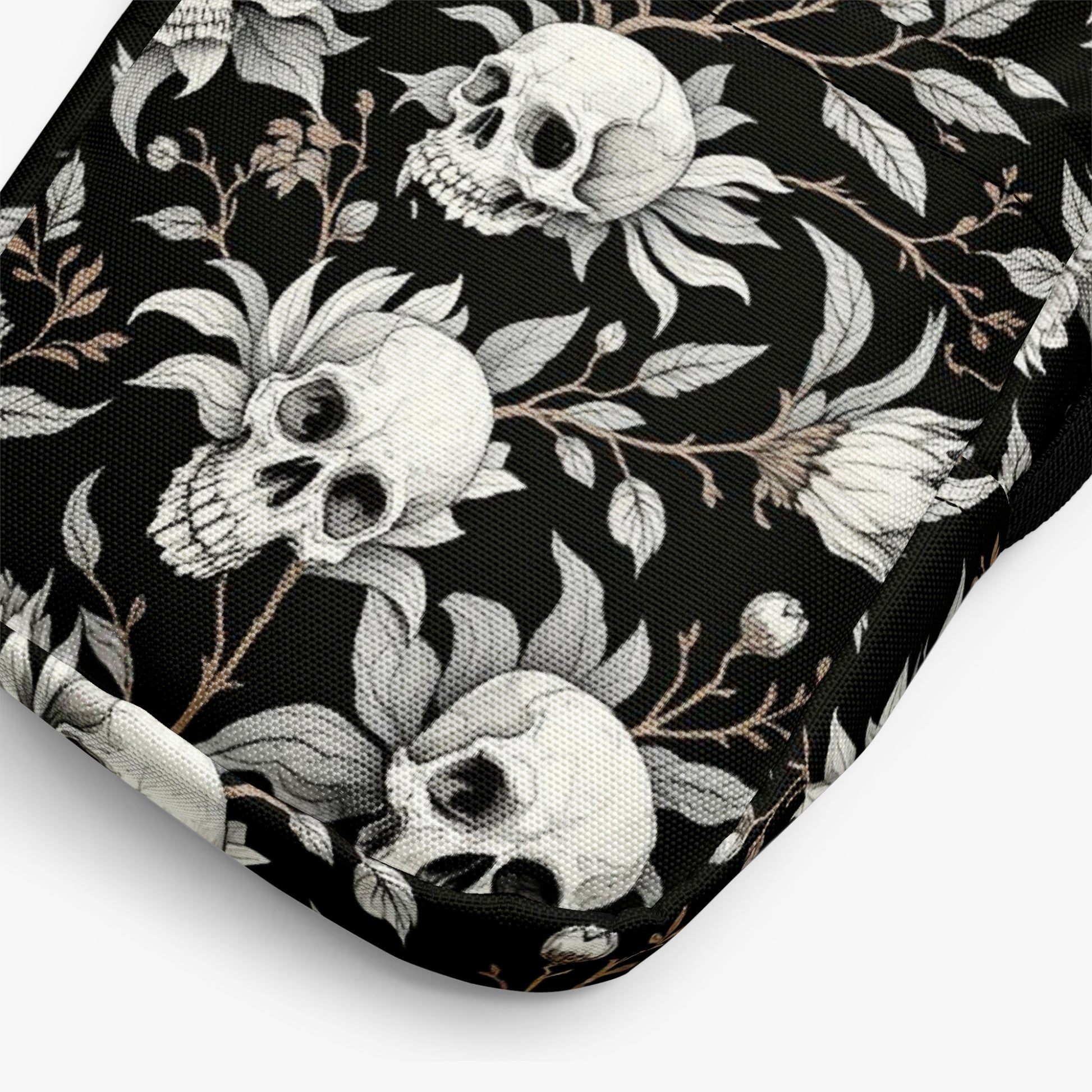 Bolso bandolera negro con calaveras y flores detalle del estampado en primer plano