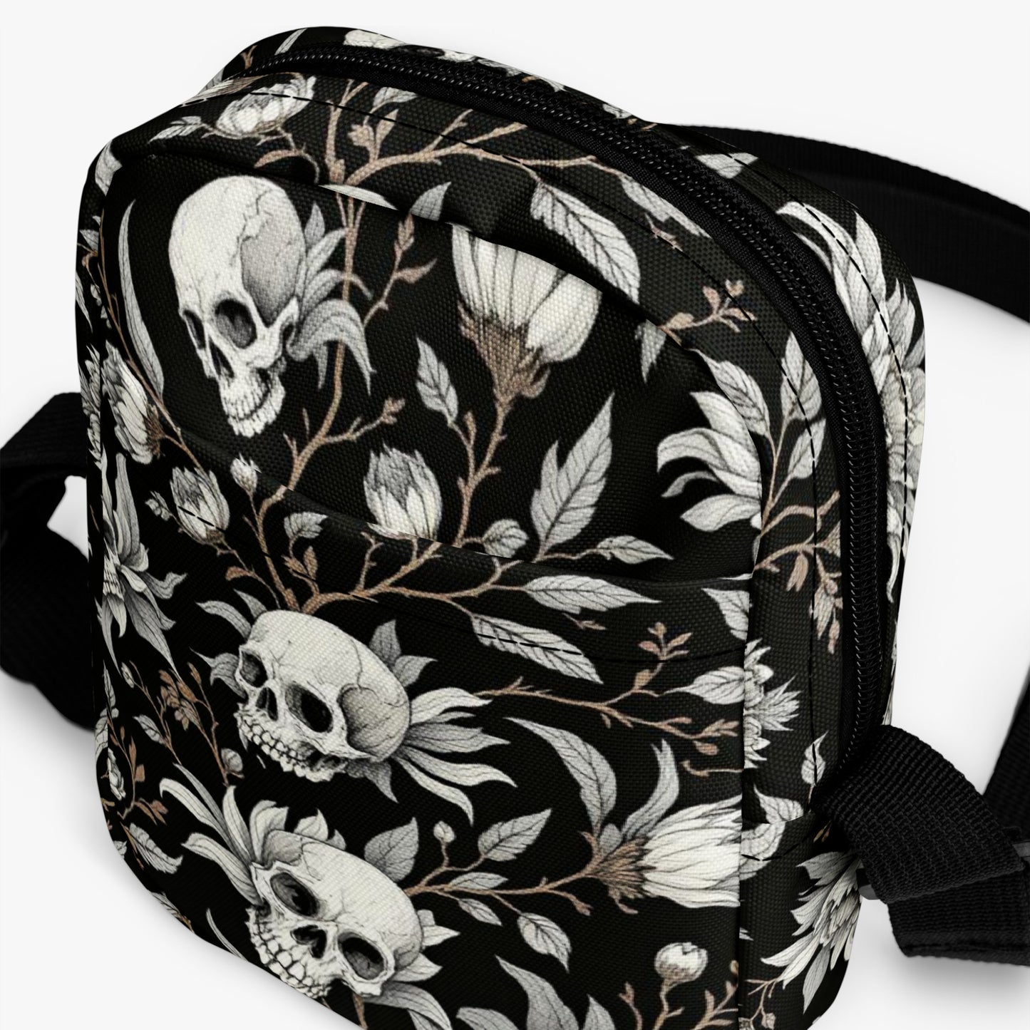 Bolso bandolera negro con calaveras y flores vista frontal del producto