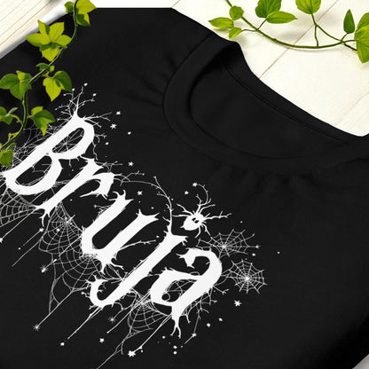 Detalle de cuello y hombro con diseño de telarañas en camiseta negra Bruja.