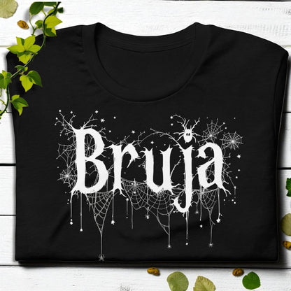 Primer plano del estampado “Bruja” en blanco con telarañas sobre camiseta negra.
