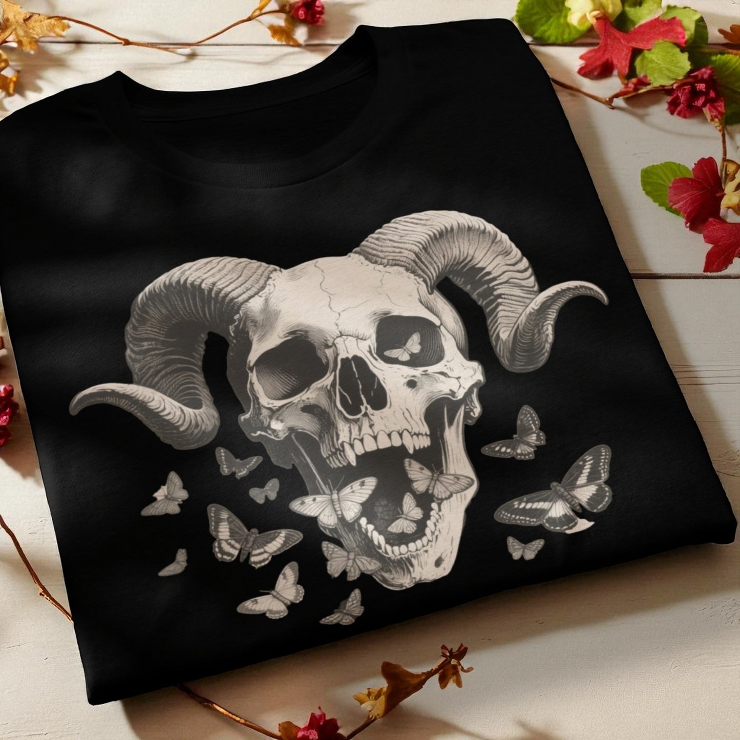 Primer plano de camiseta negra con calavera con cuernos y mariposas nocturnas detalle de cuello y estampado