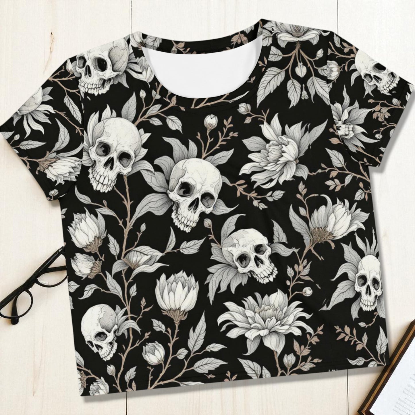 Top corto negro con calaveras y flores foto frontal en plano flat lay