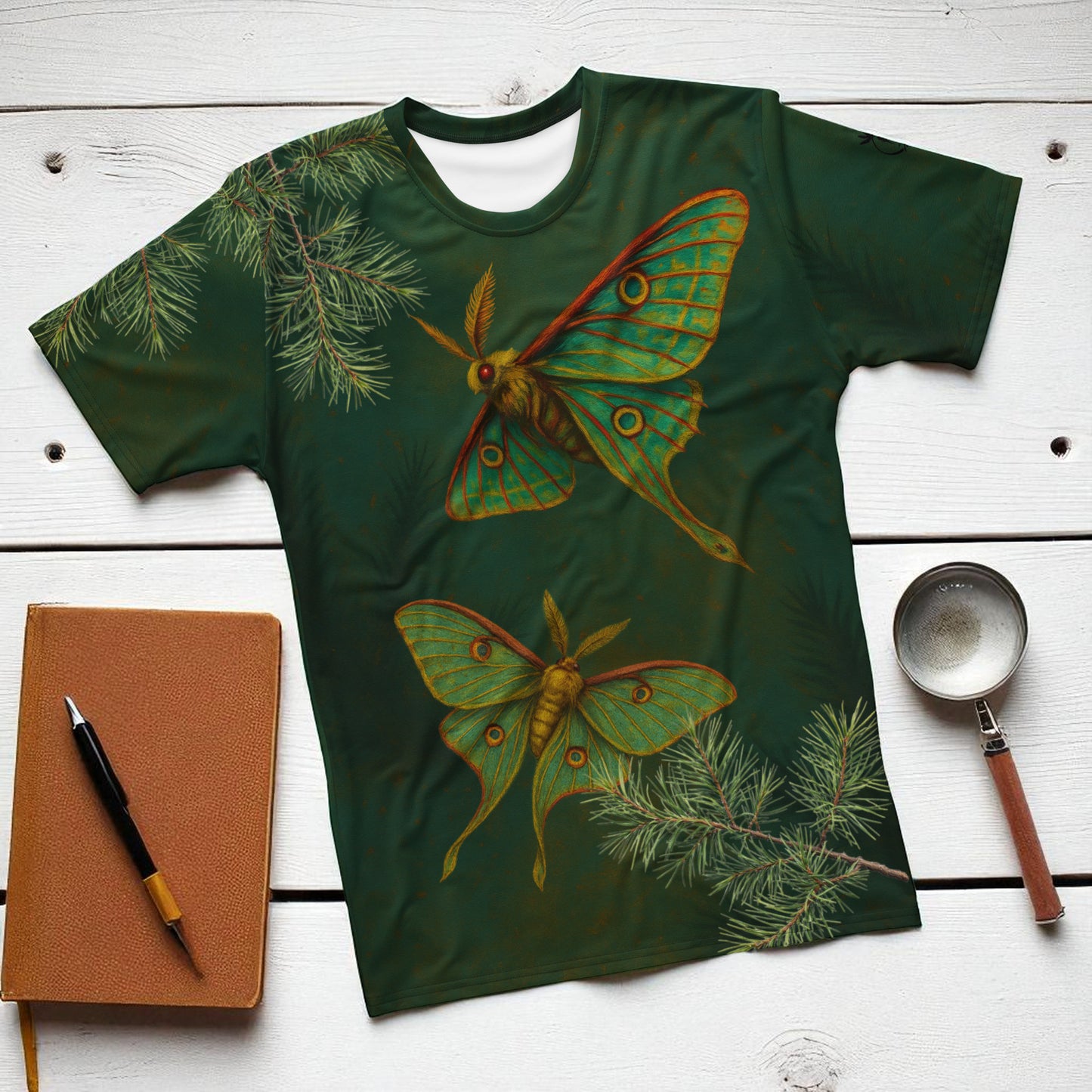 camiseta polilla verde sobre una mesa diseño frontal con dos mariposas nocturnas entre ramas de pino