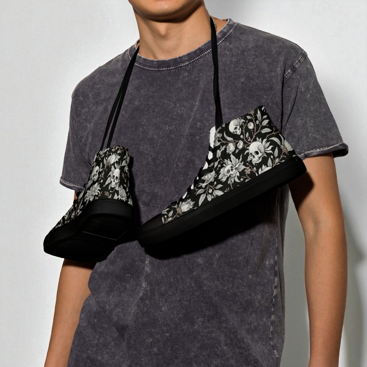 Zapatillas altas negras con calaveras y flores colgando del hombro en modelo