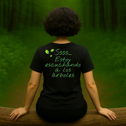 Camiseta negra unisex “Ssss… estoy escuchando a los árboles”, vista de espalda, modelo mujer en bosque
