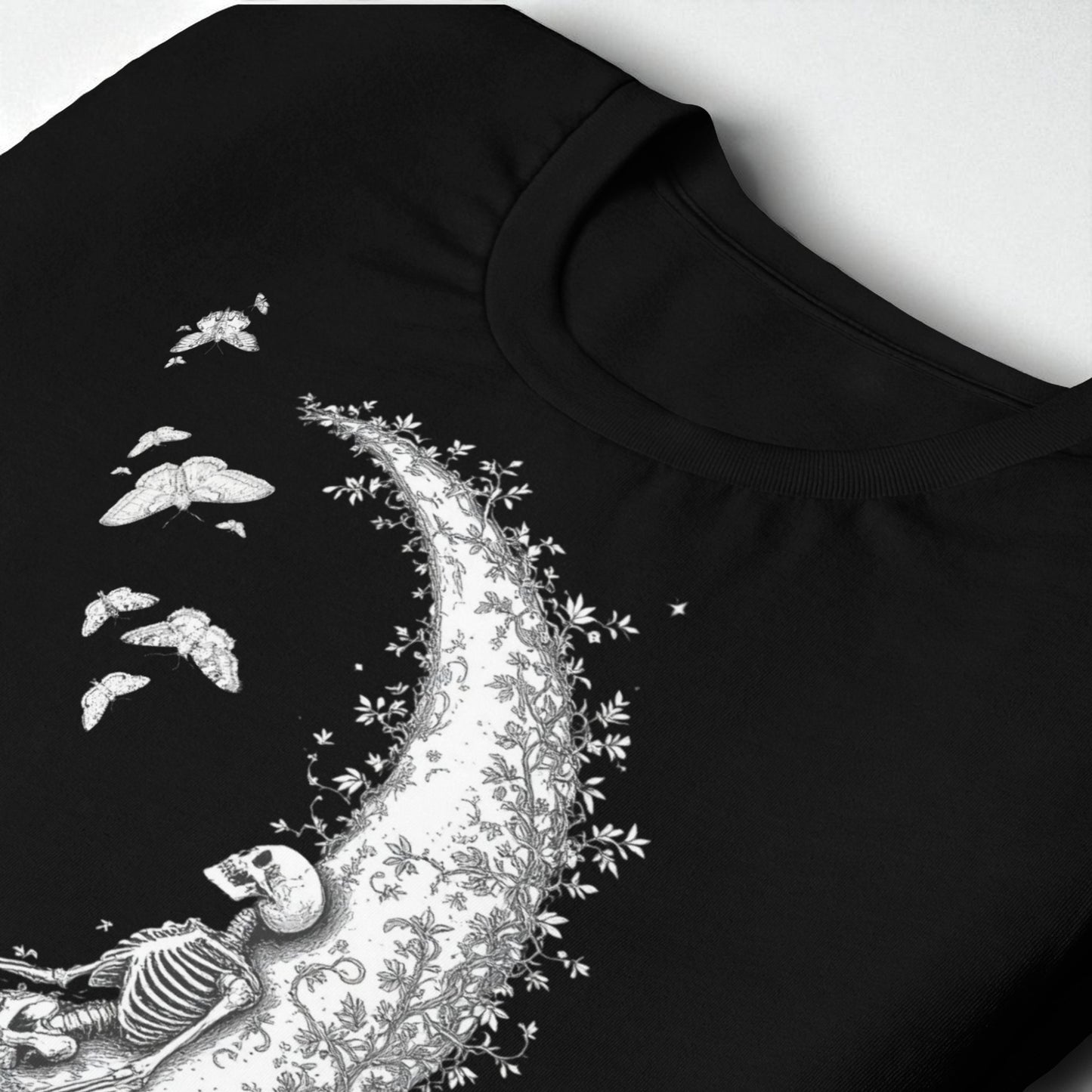 Detalle de cuello y estampado de esqueleto sobre la luna en camiseta negra