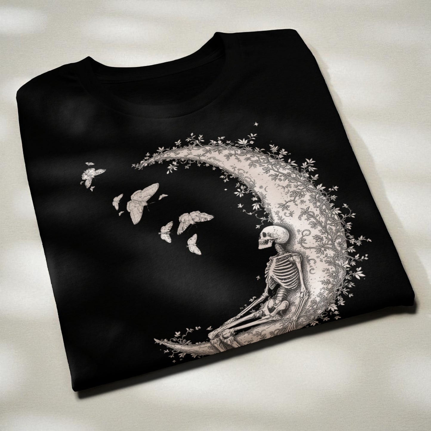 Camiseta negra con esqueleto sobre la luna fotografía en ángulo diagonal para mostrar el estampado