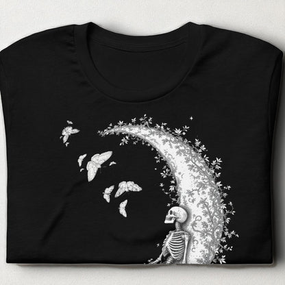 Camiseta negra con esqueleto sobre la luna doblada sobre mesa
