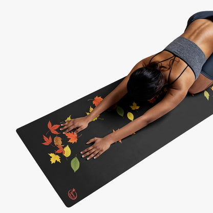 mujer practicando yoga en esterilla con hojas de otono