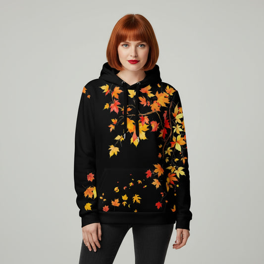 Modelo con sudadera negra con capucha y estampado de hojas otoñales en pecho y mangas.