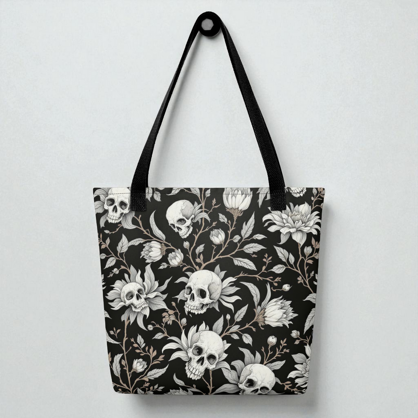 Bolso tote de hombro negro con estampado de calaveras y flores, vista frontal, asas negras