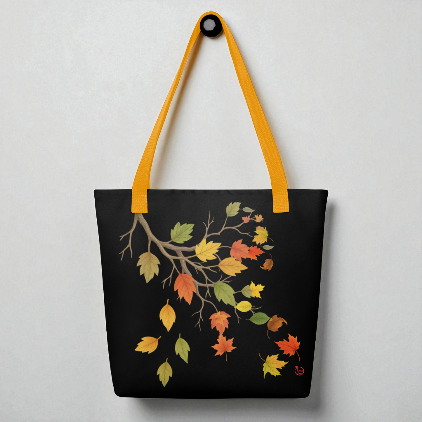 Bolso tote negro con hojas otoñales y asas amarillas, vista frontal