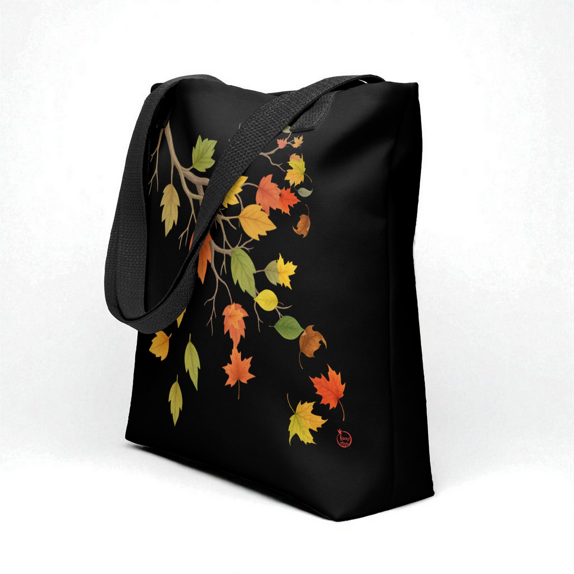 Bolso tote negro con estampado de hojas otoñales y asas negras, vista 3/4