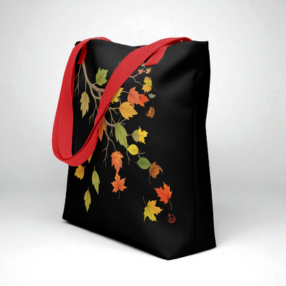 Bolsa tote negra con hojas de otoño, asas rojas, vista 3/4 para profundidad