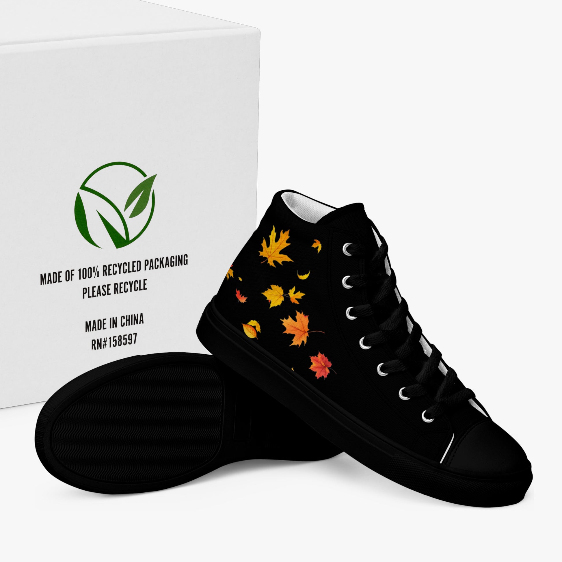Zapatillas de lona negras de mujer con hojas de otoño, presentadas en caja ecológica 100 % reciclada y con suela visible (vista lateral exterior)